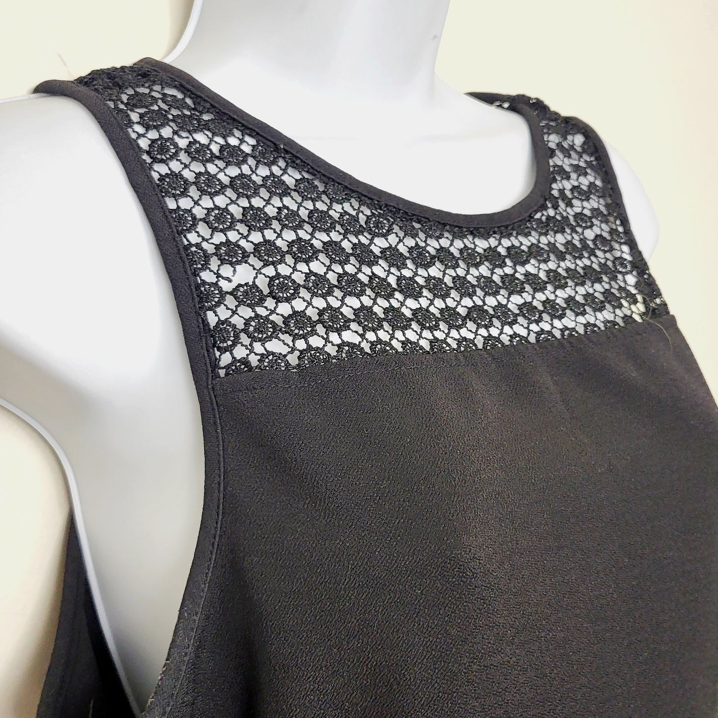 AMRO1 - Kismet black sleeveless peplum top with flower detail. Size large (closer to a medium)