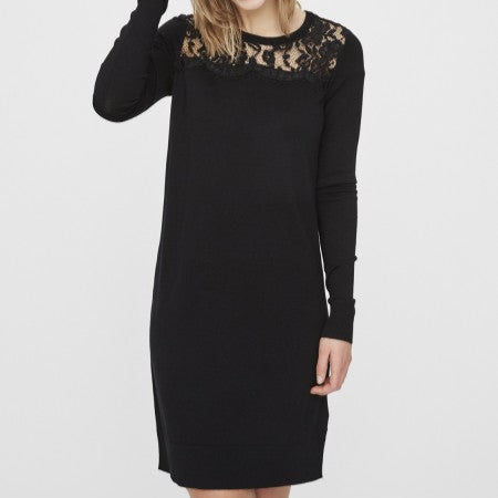 Woman wearing a black dress with lace details on a white background